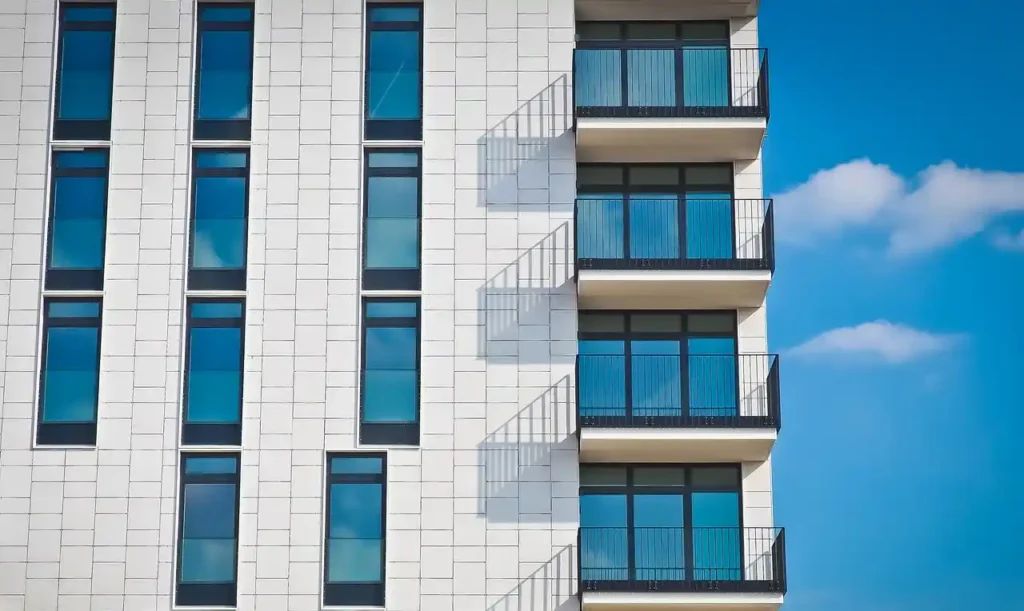 Manhattan Contracting: Modern Multi-Apartment Duplex with Glass Windows and Exterior Staircase Multi-apartment duplex residential building with sleek glass windows and an exterior-mounted staircase, designed and constructed by Manhattan Contracting, general contractors in NYC.