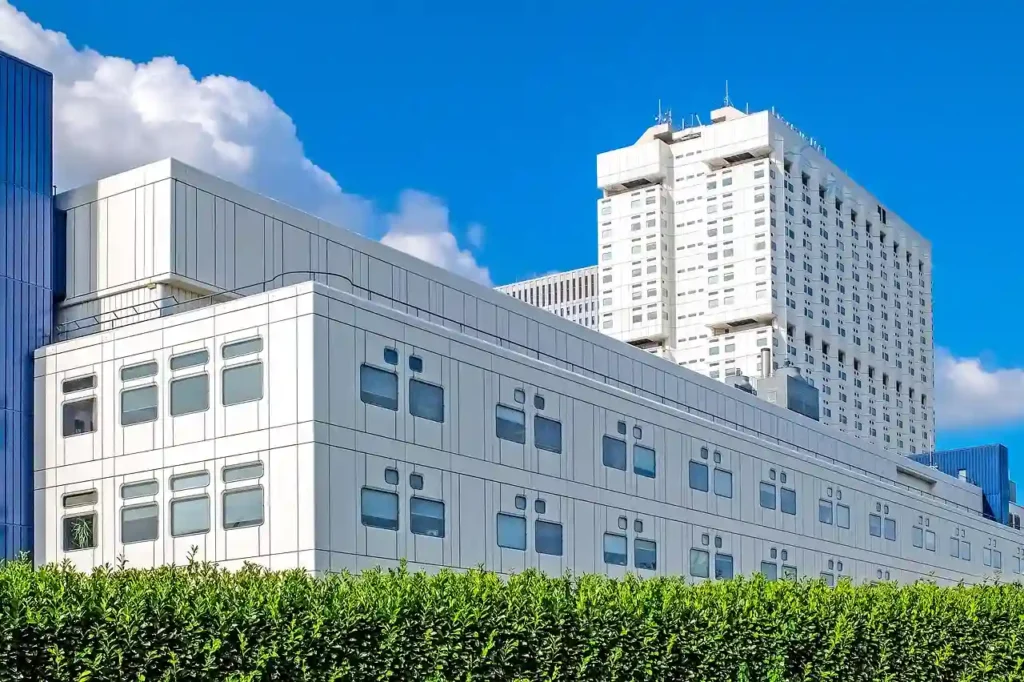 Modern hospital with trees in front and the sky in the background, designed and built by Manhattan Contracting, offering new construction services in NYC for healthcare facilities.
